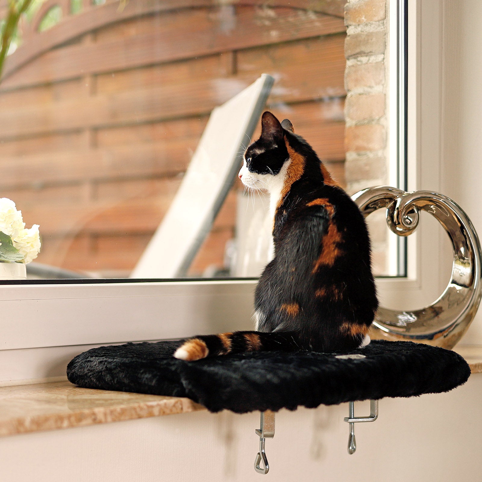 Tumbona para gatos en el alféizar de la ventana
